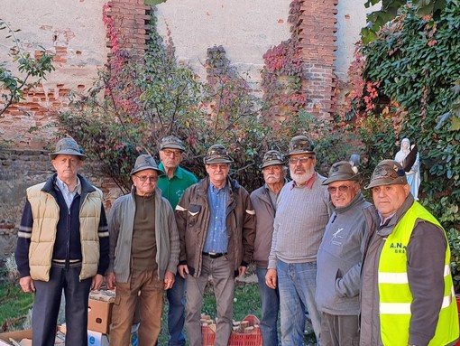 Un gruppo di Penne Nere braidesi con al centro il capogruppo Tino Genta, impegnato nella castagnata