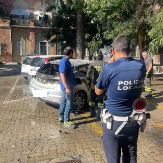 La Polizia Locale di fronte all'auto distrutta