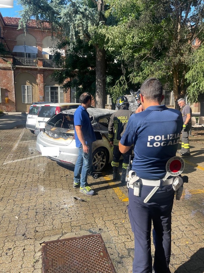 La Polizia Locale di fronte all'auto distrutta